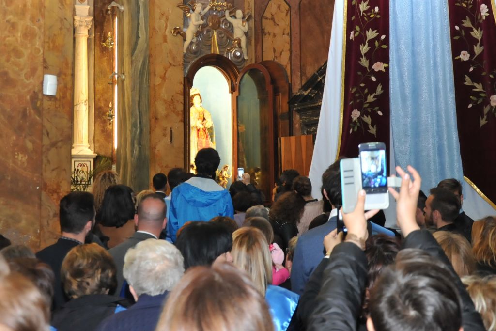 I fedeli accompagnano la Madonna nella sua abituale nicchia